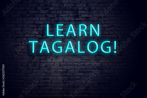 Brick wall and neon sign with inscription. Concept of learning tagalog photo