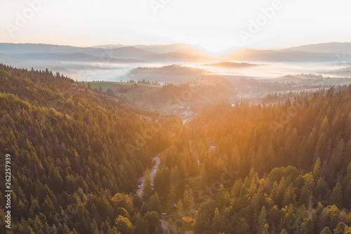 aerial view of sunset over mountains with forest and river © phpetrunina14