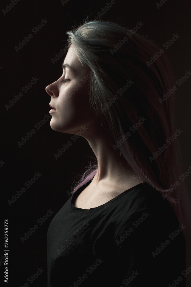 Fototapeta premium Young woman with dyed hair. Profile. Low key