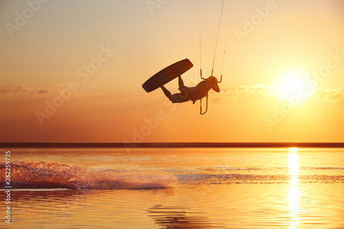 Kitesurfer at sunset with jump