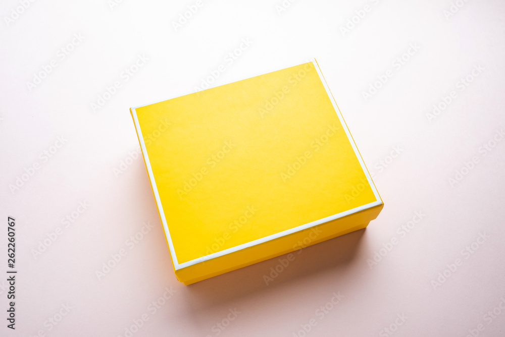 a yellow gift box on a pink background a yellow gift box on a pink background