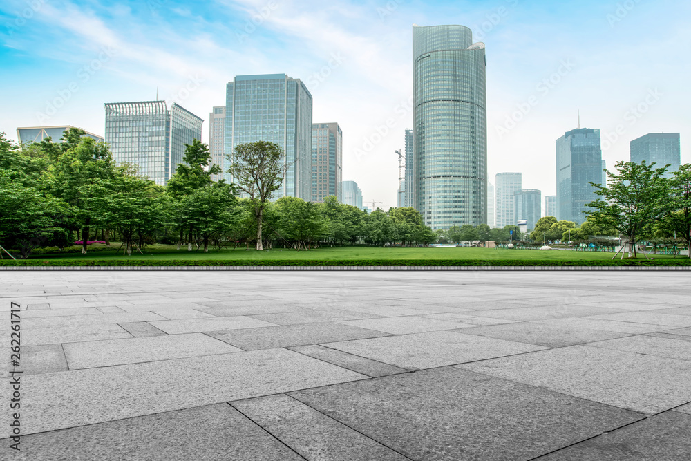 Empty square tiles and skyline of urban buildings..