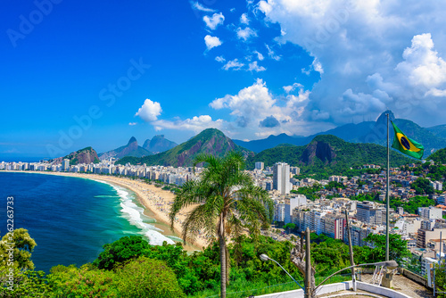 Copacabana beach in Rio de Janeiro, Brazil. Copacabana beach is the most famous beach of Rio de Janeiro, Brazil. Skyline of Rio de Janeiro with flag of Brazil photo