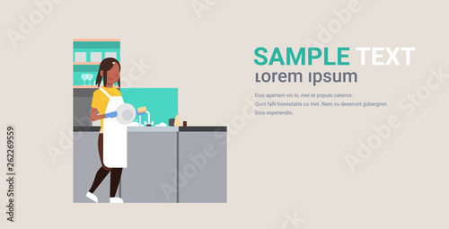 young woman washing dishes african american girl wiping plates on kitchen dishwashing concept housewife doing housework flat horizontal copy space full length