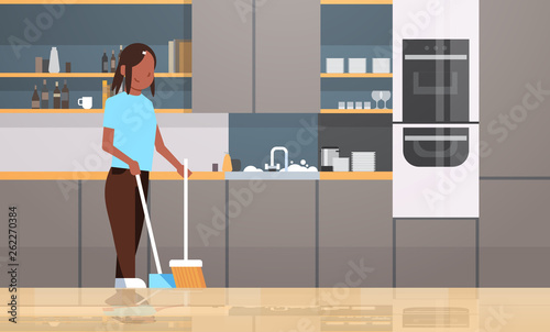 housewife sweeping floor with broom and scoop african american girl doing housework house cleaning concept modern kitchen interior female character full length horizontal