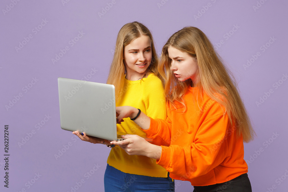 Two charming young blonde twins sisters girls in vivid colorful Two charming young blonde twins sisters girls in vivid colorful