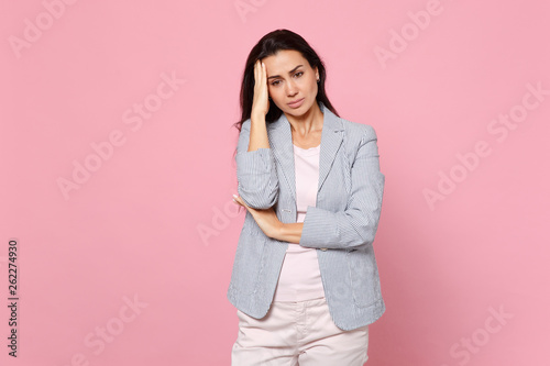 Portrait of displeased preoccupied young woman in striped jacket putting hand on head isolated on pink pastel wall background in studio. People sincere emotions, lifestyle concept. Mock up copy space. © ViDi Studio