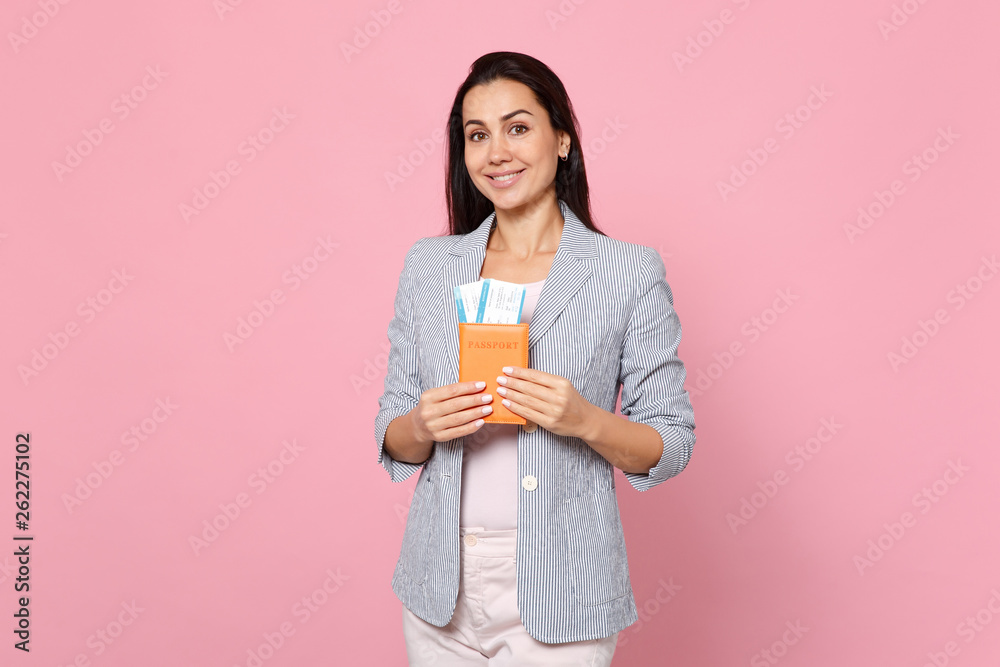 Attractive cute young woman in striped jacket holding passport, boarding pass ticket isolated on pink pastel wall background in studio. People sincere emotions, lifestyle concept. Mock up copy space. Attractive cute young woman in striped jacket holding passport, boarding pass ticket isolated on pink pastel wall background in studio. People sincere emotions, lifestyle concept. Mock up copy space.