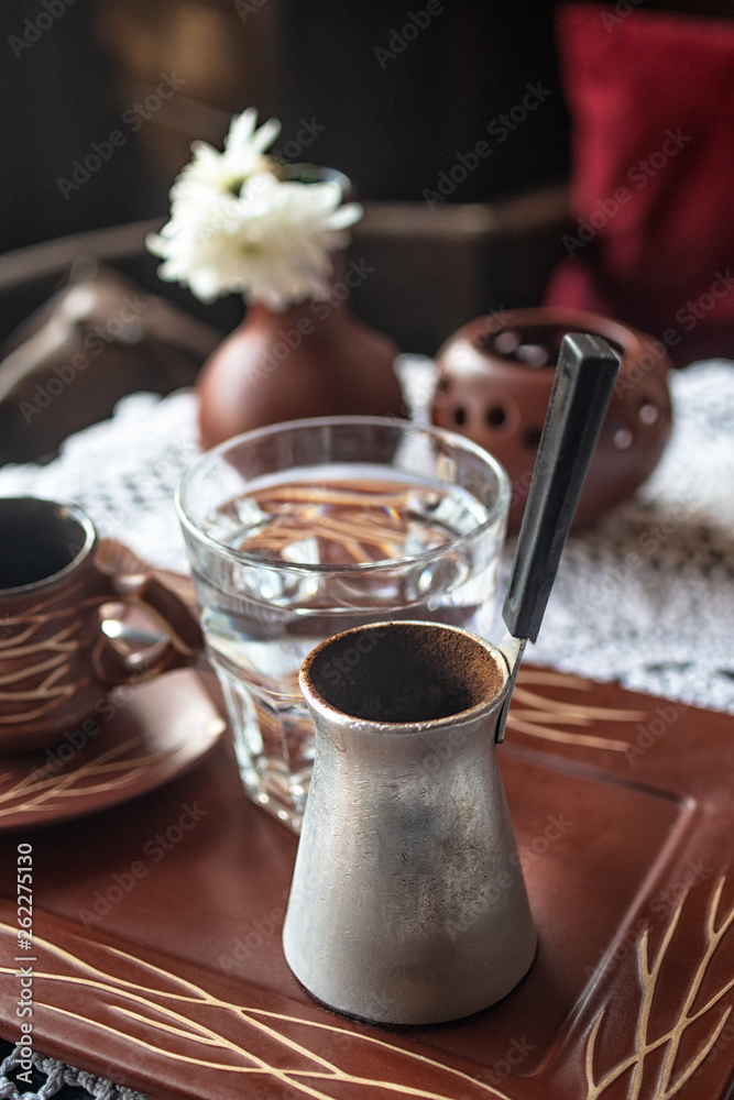 Obraz premium Turkish coffee with glass of water served on table.