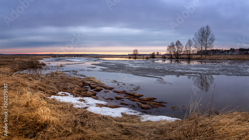 Fototapeta Naklejka Na Ścianę i Meble -  spring sunset panorama with trees on the river Bank and ice, Russia, Ural, April,