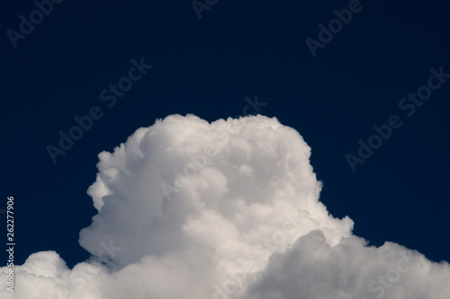 White cotton clouds on a dark blue sky