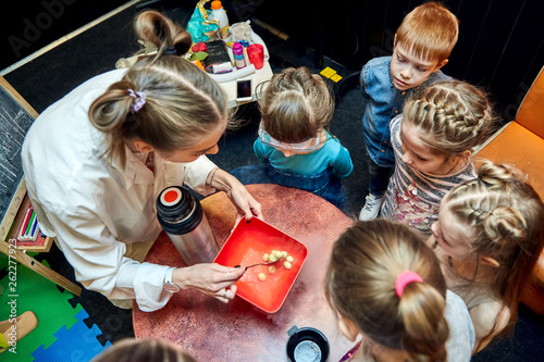 Chemical show for kids. Professor carried out chemical experiments with liquid nitrogen on Birthday little girl. photo