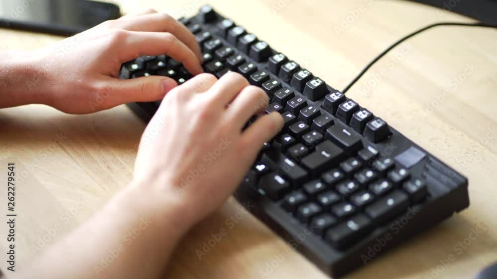 A male person is typing on a mechanical keyboard using the ten finger system A male person is typing on a mechanical keyboard using the ten finger system