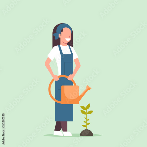female farmer growing young seedling plant flower or vegetable woman holding watering can gardener in uniform agricultural eco farming concept flat full length