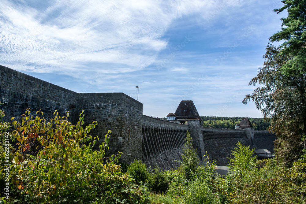 Blick auf die Talsperre, entlang der Sperrmauer aus dem tiefen Tal