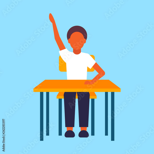 schoolboy sitting desk african american male pupil raising hand during lesson education concept elementary school full length flat blue background