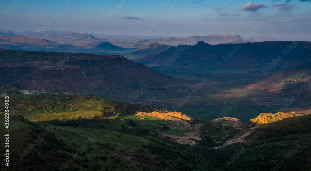 Naklejka premium Landscape view over mountains and the sun shining through the clouds, Lesotho, Africa