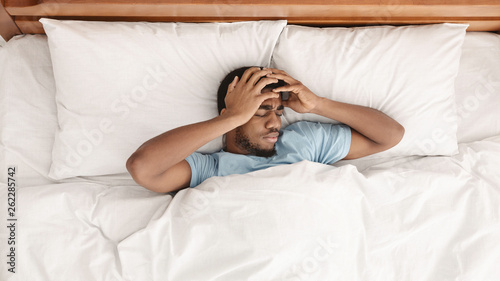 Canvas Print Restless african american man waking up with headache