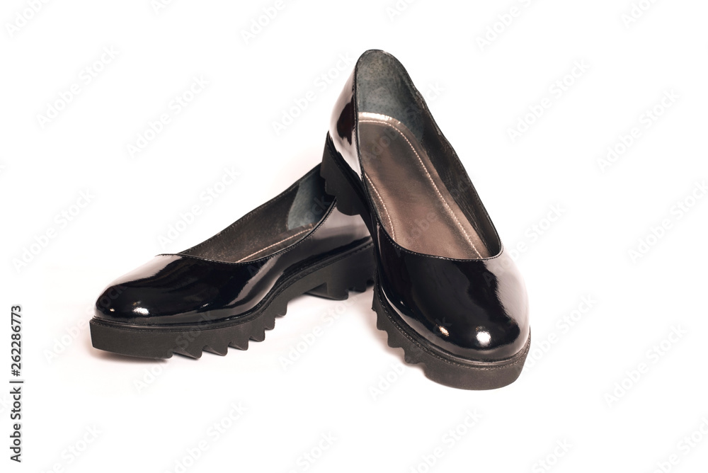 Beautiful black lacquered shoes for women on a white background for rainy weather Beautiful black lacquered shoes for women on a white background for rainy weather