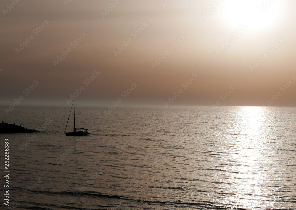 suggestiva foto di una barca al mare in lontananza al tramonto