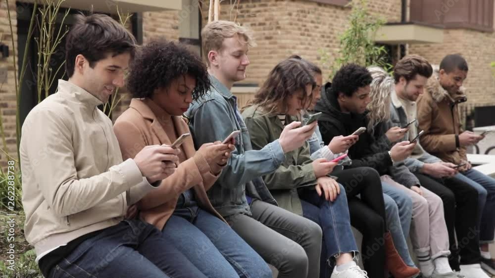 Multiracial group of friends with smartphones in the city Multiracial group of friends with smartphones in the city
