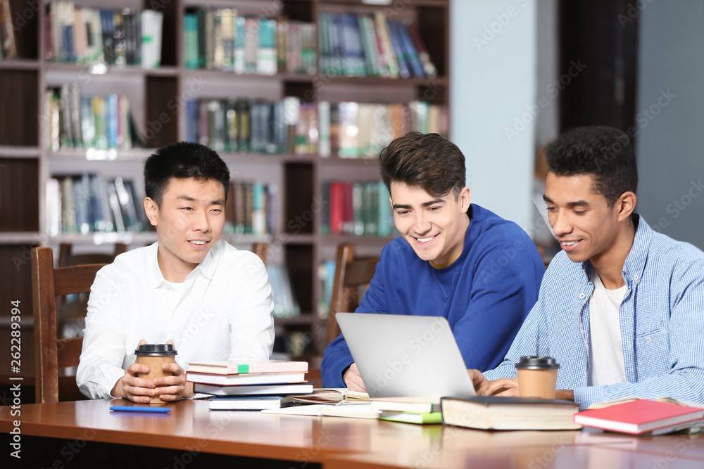 Group of students studying at table in library