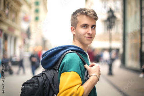 Teenager walking in the street, carrying a backpack on one shoulder
