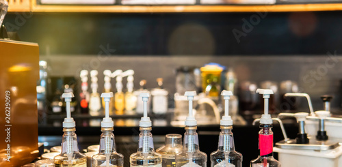 Pump at the head of bottles for caramel, syrup and smell addition for coffee in cafe. photo