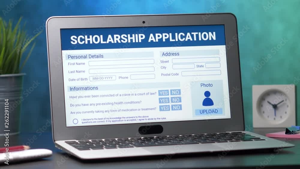 Laptop computer with a scholarship application form on its display. Camera turning slowly around the desk.