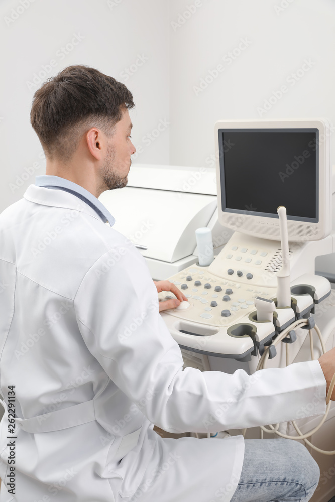 Sonographer operating modern ultrasound machine in clinic Sonographer operating modern ultrasound machine in clinic