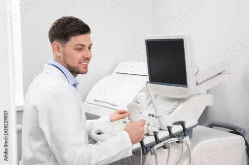 Sonographer operating modern ultrasound machine in clinic