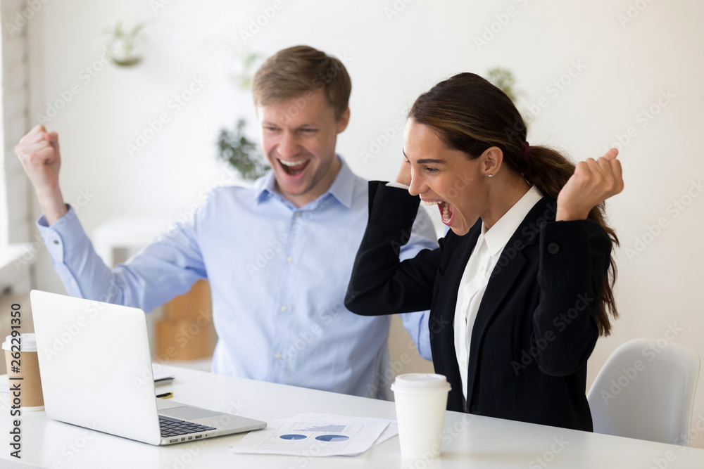Excited man and woman clenching fists after successful job interview