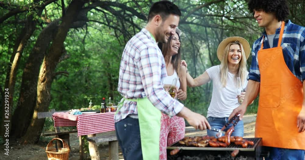 Happy friends having a barbecue party in nature