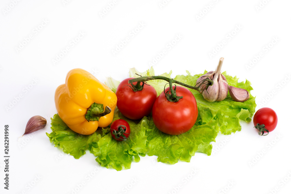 Yellow and red tomatoes on a white background. Bulgarian pepper. Yellow sweet pepper with garlic and tomatoes on a white background. Red tomatoes and sweet yellow pepper on a white background.