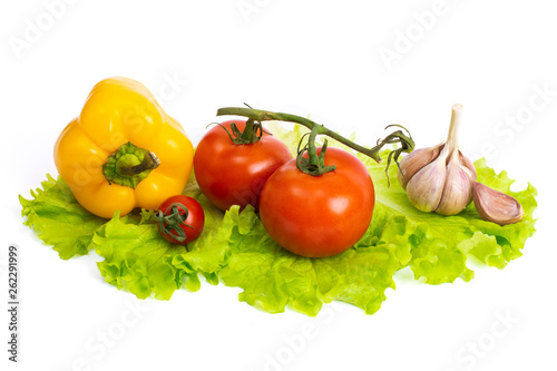 Yellow and red tomatoes on a white background. Bulgarian pepper. Yellow sweet pepper with garlic and tomatoes on a white background. Red tomatoes and sweet yellow pepper on a white background.