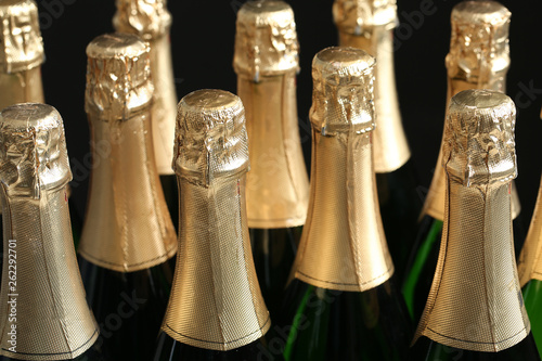 Many bottles of champagne on dark background, closeup