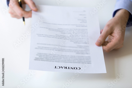 Businessman reading and checking terms and conditions at contract document