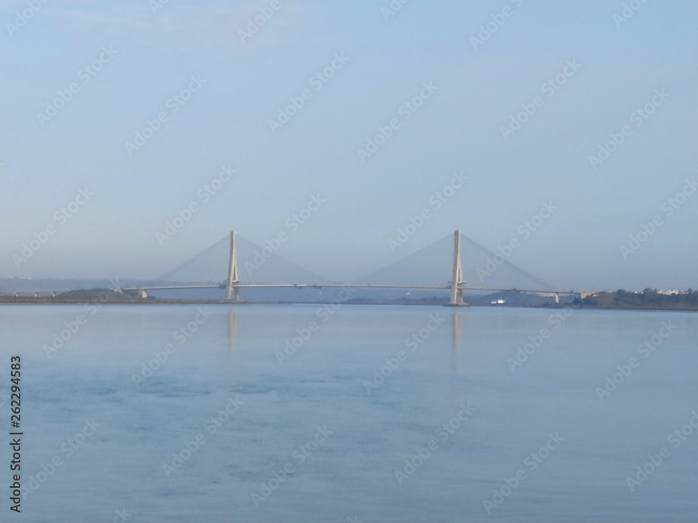 El mar en Ayamonte con El puente Internacional, un puente colgante entre España y Portugal, en la parte posterior 