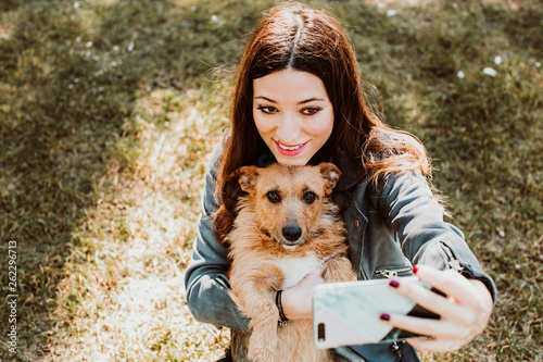 Tableau sur toile .Pretty young woman playing with her dog in the park outdoors. Taking pictures t