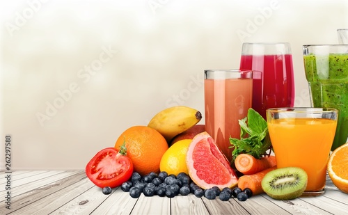 Tasty fruits and juice with vitamins on background
