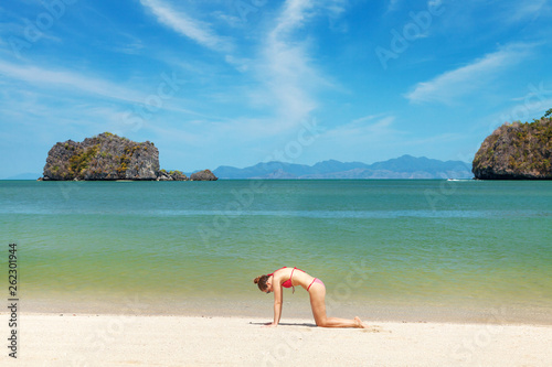 Young woman practice yoga on a beach