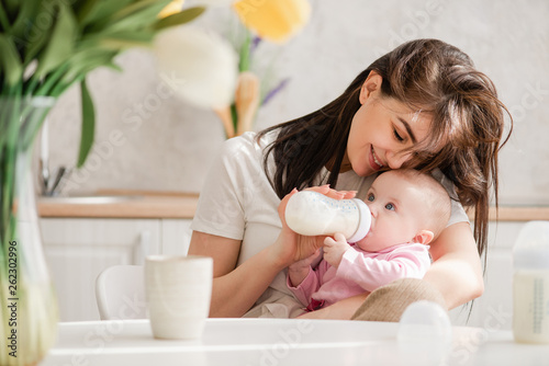 Feeding newborn girl with formula in a bottle.