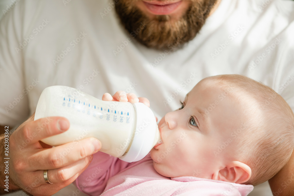 Close-up of feeding newborn with formula in a bottle. Close-up of feeding newborn with formula in a bottle.