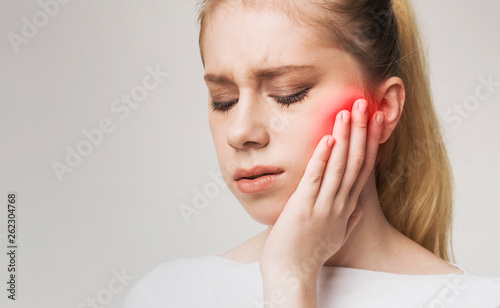 Young womanhaving strong toothache and suffering from pain photo