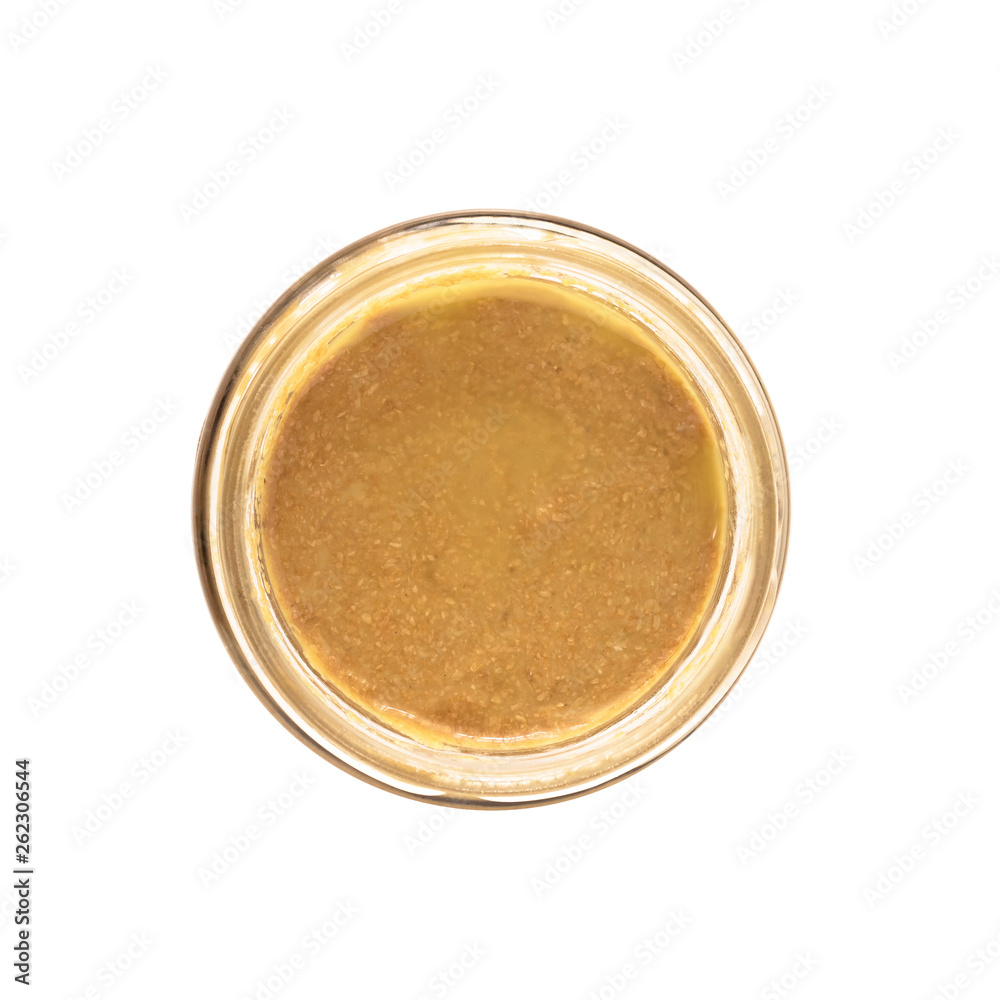 Top view of open glass jar with nut butter, hummus or sesame paste tahini isolated on white background Top view of open glass jar with nut butter, hummus or sesame paste tahini isolated on white background
