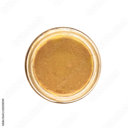 Top view of open glass jar with nut butter, hummus or sesame paste tahini isolated on white background