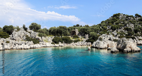 a view of the yacht on the blue waters and the various mountain scenery on the blue sky; travel pleasure in summer