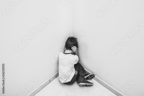 child in school uniform crying and hiding his face. photo