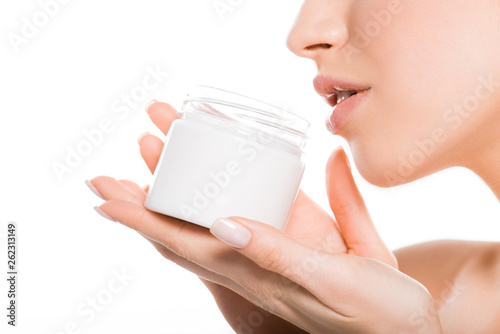Fototapeta Naklejka Na Ścianę i Meble -  cropped view of woman holding container with cosmetic cream isolated on white