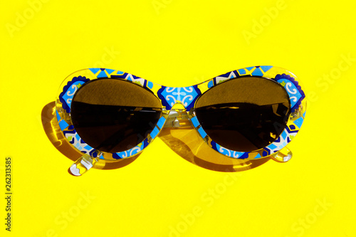 Travel, Vacation, Sale, Summer Concept. Blue Sunglasses On Yellow Background. Top View Of Sunglasses In Colorful Frame.